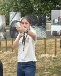 Une élève précisant sa technique auprès du public, ayant posé une question, en arrière plan une vue de la série de photo réalisée cette année