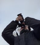 eleve_vu_en_contre_plongee_avec_a_la_main_un_appareil_photo_numerique_reflex_en_train_de_photographier