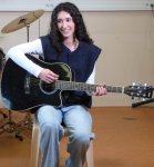 eleve_mise_en_scene_jouant_de_la_guitare_avec_un_eclairage_naturel_et_un_eclairage_artificiel_oriente_sur_son_visage