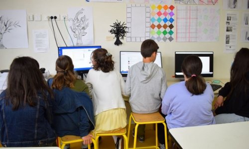 photographie d'élèves travaillant en groupe aux ordinateurs