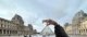 eleve_devant_la_pyramide_du_louvre_jouant_a_faire_croire_qu_elle_la_tient_du_bout_des_doigts_s_esssayant_au_jeu_des_rapports_d_echelle